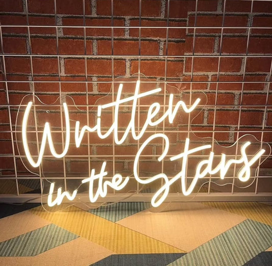 Letrero de neón con texto en inglés <<Written In The Stars» ...
